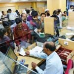बैंक शाखा के काउंटर पर काम कराते ग्राहक