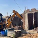 बागोदा में अवैध निर्माण हटाती जेसीबी