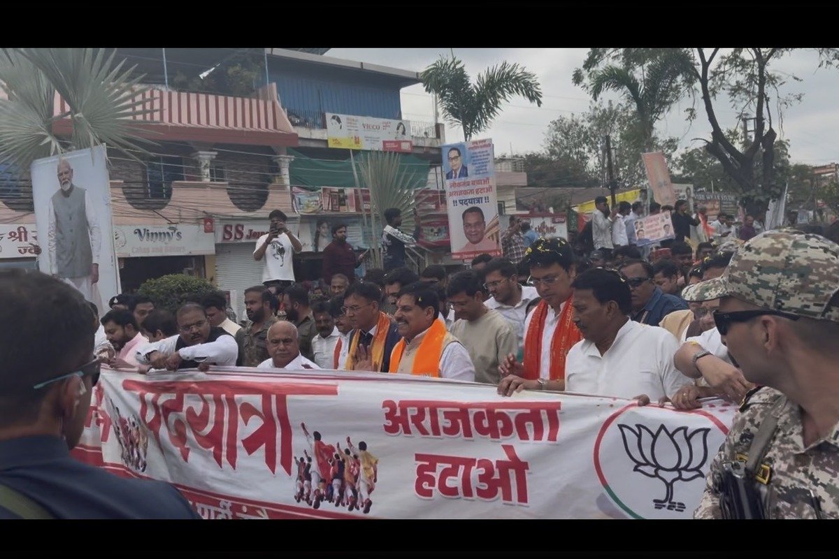 बैनर थामे पदयात्रा में चलते नेता